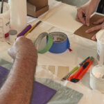 detail of hands gluing papers