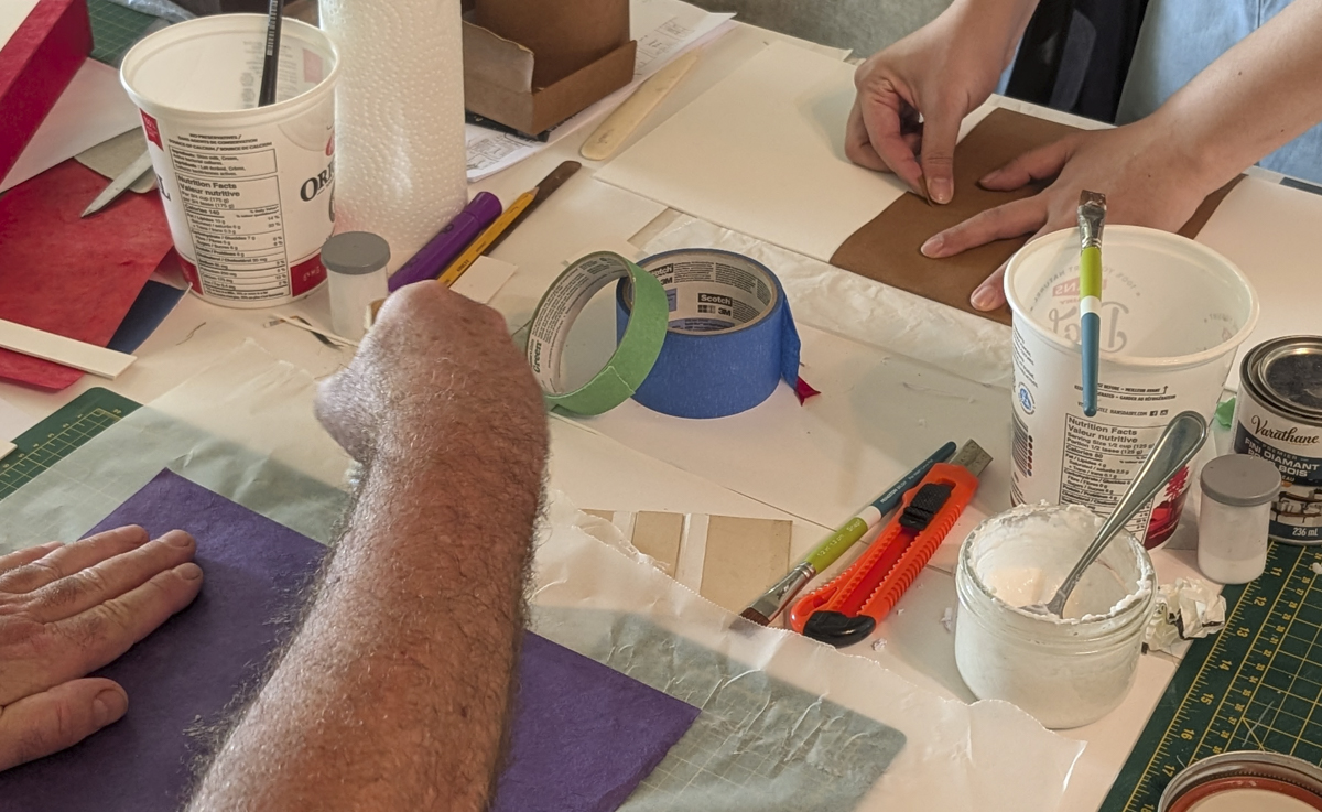 detail of hands gluing papers