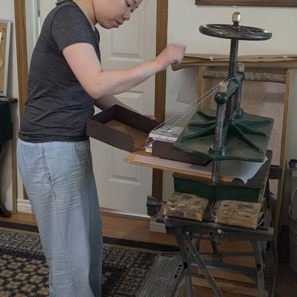 placing clamshell box in press while gluing