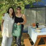 two women posing by picnic table