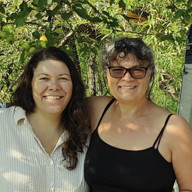 two women posing by picnic table