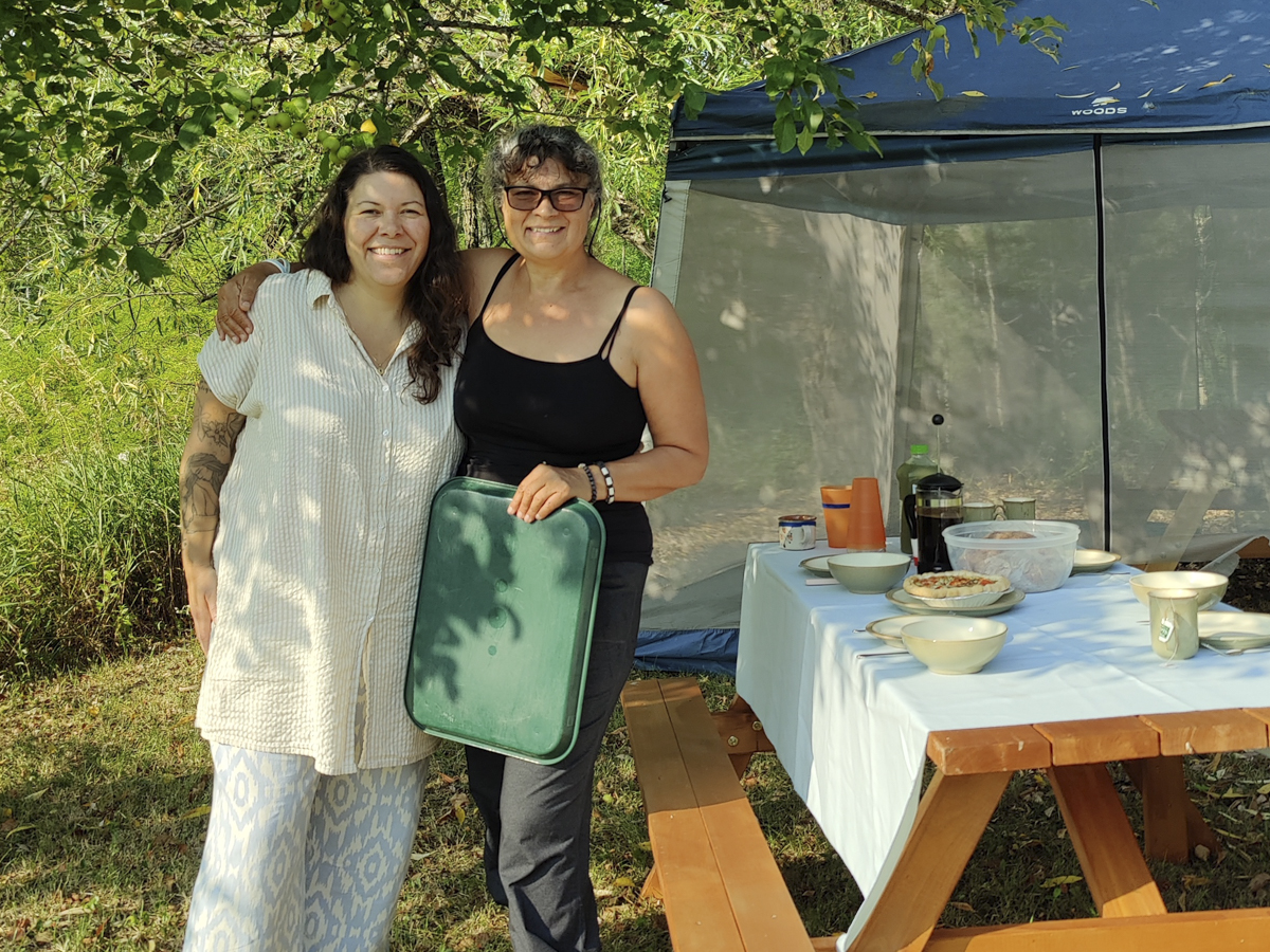 two women posing by picnic table
