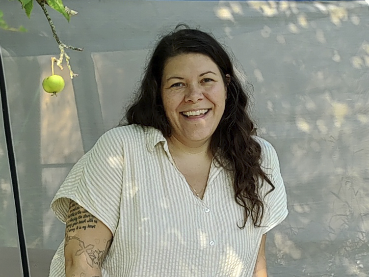 smiling woman in the shade with hanging apple